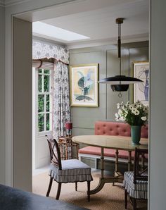 the dining room is decorated in pink and blue tones with white flowers on the table