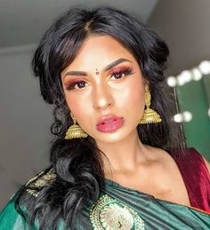 a woman in a green sari with gold jewelry