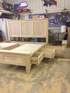 an unfinished bed frame with drawers in a garage