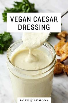 a spoon full of vegan caesar dressing on top of a table with other ingredients