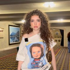 a young woman with curly hair wearing a t - shirt that has an image of her face on it