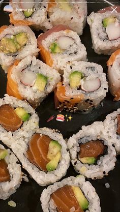 sushi rolls are arranged on a black plate