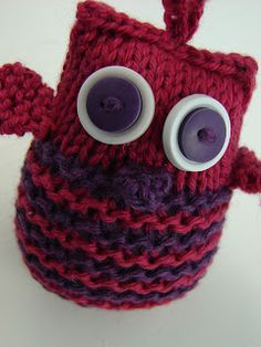 a red and purple knitted object with googly eyes