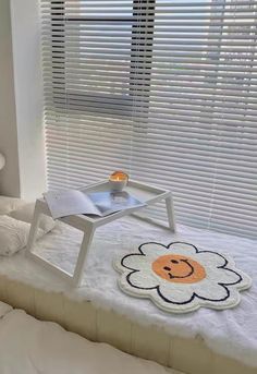 a bed with a flower shaped rug on top of it in front of a window