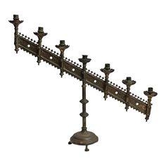 an old fashioned metal candelabra with candles on it's sides, isolated against a white background