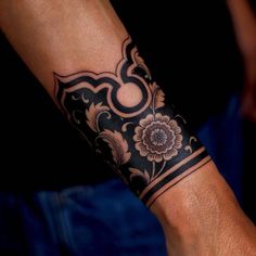 a man's arm with a tattoo on it and a flower in the middle