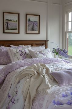 a bed with purple and white comforters in a bedroom next to two windows,