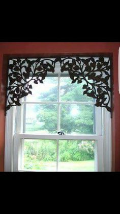 the window is decorated with an intricately designed valance, and has a bird on it