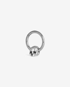 a silver ring with a skull on the front and back ends, set against a white background