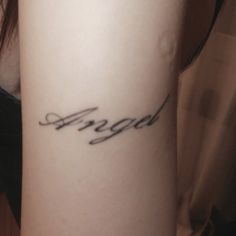 a woman's arm with the word angel written in cursive writing on it