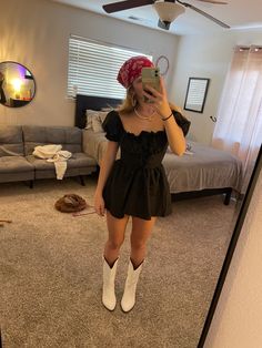 a woman is taking a selfie in the mirror while wearing boots and a hat