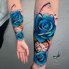 two blue roses are on the arm and one is painted with watercolors, while the