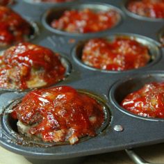 a muffin tin filled with meatballs covered in sauce