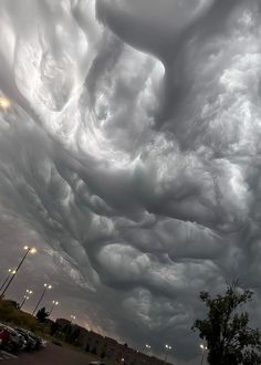 the sky is filled with clouds and cars