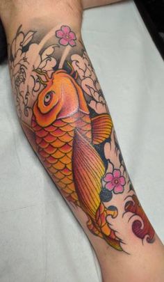 a man with a tattoo on his arm has a koi fish in the water