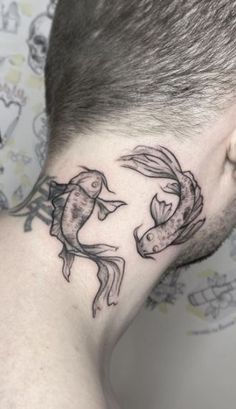 a man's neck with two fish on it and one fish in the middle