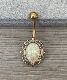 This unique faux opal belly button ring is made with surgical steel and a gorgeous gold coating. With a minimalist and vintage design, this is great for everyday wear! Drop jaws with our body jewelry! Details & Size: ♥ 316L Surgical Steel ♥ 14G, 10mm bar length ♥ Every purchase comes with an Elara gift box Please message me if you have any questions We hope you love our jewelry as much as we do! Cute Septum Rings, Unique Belly Rings, Dope Jewelry Accessories, Cool Ear Piercings