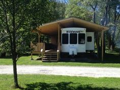 a white rv parked in front of a wooden cabin