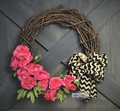 a wreath with pink flowers and chevron bows