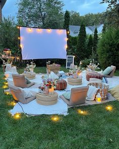 an outdoor movie is set up in the backyard for a party with lights on it