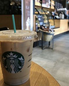 a starbucks drink sitting on top of a wooden table