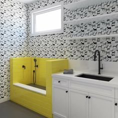 a bathroom with yellow and black wallpaper, white cabinets and a sink in front of a window