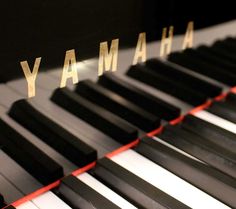 the words yamaha are written on an old piano