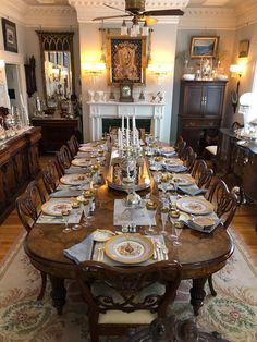 a dining room table set with place settings