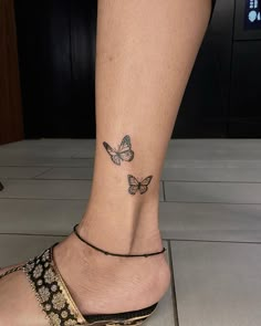 a woman's foot with a butterfly tattoo on her left ankle and the bottom part of her leg