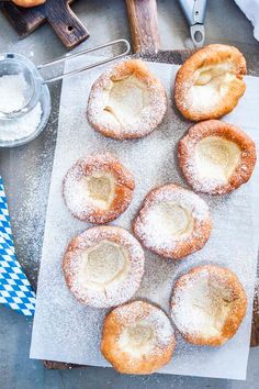 there are some powdered doughnuts on the table with blue and white napkin