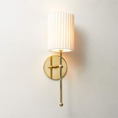 a wall light with a white shade on it's side and a gold arm