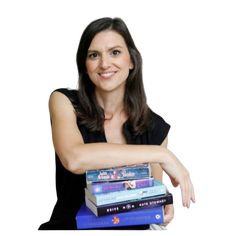 a woman is holding three books in her hands and posing for the camera with one hand on top of them