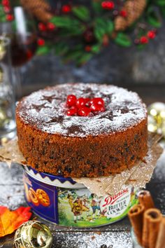 christmas fruit cake traditional style recipe in a tin with holly berries and cinnamon on top