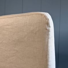 a close up view of the back end of a beige chair with white piping