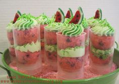 cupcakes with green frosting and watermelon slices on top are arranged in cups