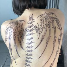 the back of a woman with tattoos on her body