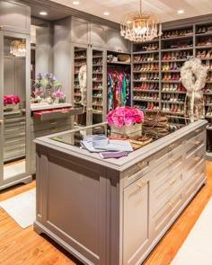 a large closet filled with lots of shoes and vases on top of a counter