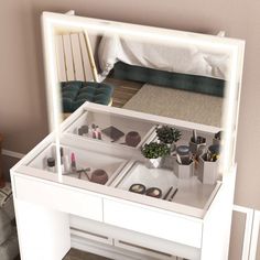 a white vanity with drawers and lights on the top, in front of a bed