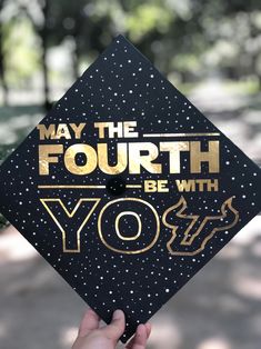 someone holding up a graduation cap that says, may the fourth be with you