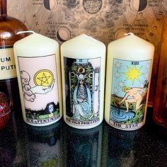 three candles sitting on top of a counter next to bottles