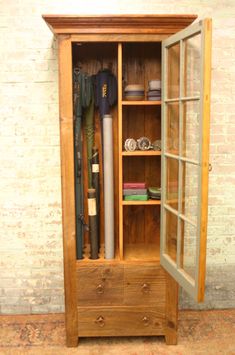 an old wooden cabinet with baseball bats and other items in glass doors on the inside