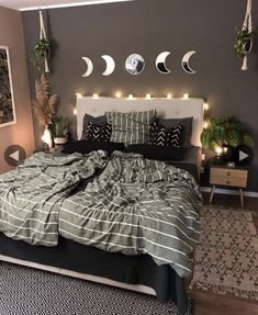 a bed room with a neatly made bed and lots of lights on the wall above it