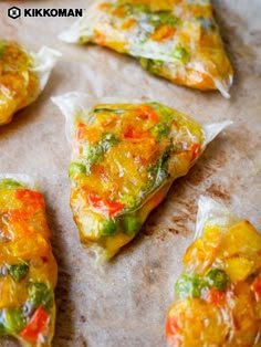 several pieces of food that have been placed on a baking sheet and are covered in plastic wrap