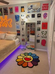 a bedroom with a bed and various pictures on the wall above it, along with a colorful flower rug