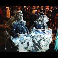 two people dressed in paper mache sitting next to each other