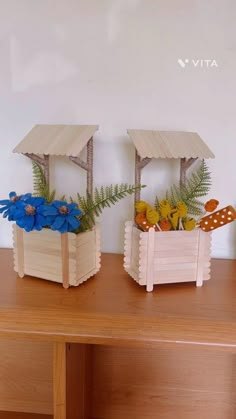 two small wooden planters with flowers in them