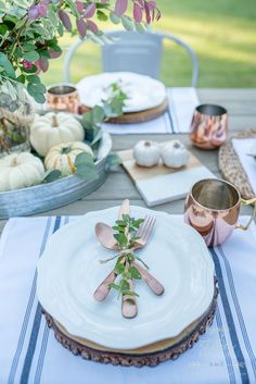 a table set with plates, silverware and napkins for an outdoor dinner party