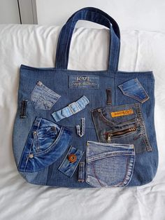 a blue jean purse with several different items in it sitting on a white bed sheet