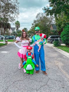 two adults and one child are dressed up as mario and luigi in the street with toys