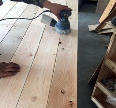 a person using a sander on wood planks